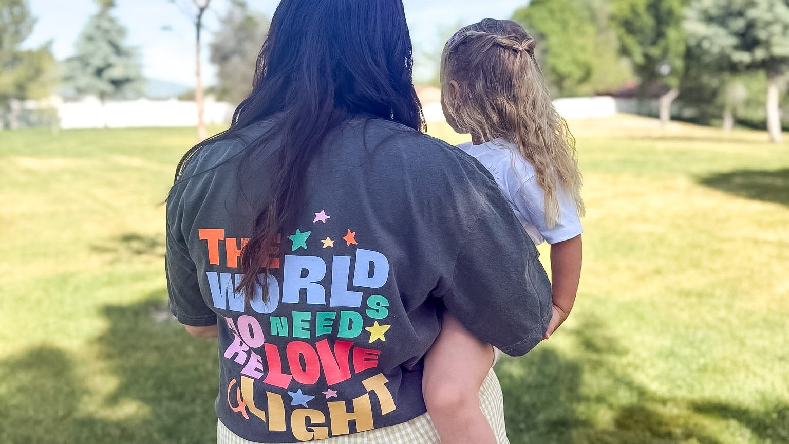 Person wearing a jacket with colorful text outdoors