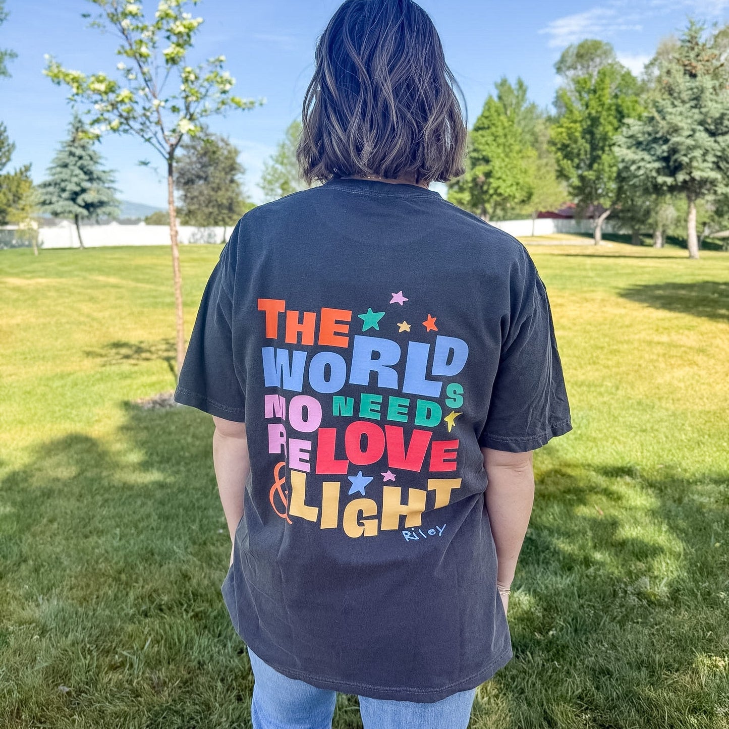 Person wearing a t-shirt with a colorful message in a park